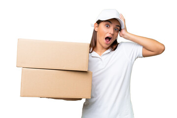 Delivery caucasian woman holding boxes isolated on green chroma background with surprise expression