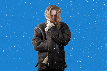 Snowfall. Winter. A person freezes in cold weather.A man in a winter jacket is standing on the...