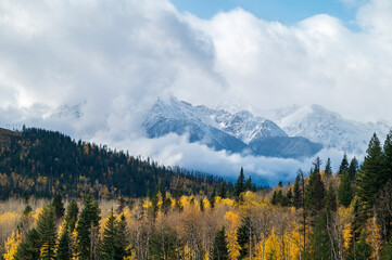 Panorama photo with mountain peaks and low hanging clouds in Canadian Rockies