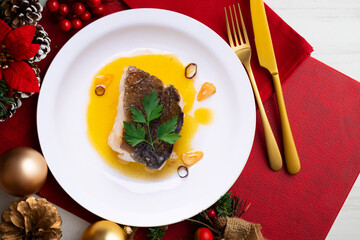 Cod pil pil tapa on a table decorated with Christmas motifs. Traditional Spanish recipe.