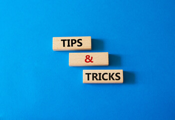 Tips and tricks symbol. Wooden blocks with words Tips and tricks. Beautiful blue background....