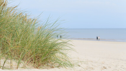 Strand an der Küste von Swinoujscie an der polnischen Ostseeküste. Im Hintergrund unscharfe Spaziergänger.