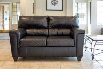 Black leather sofa stands in the living room. Loft interior