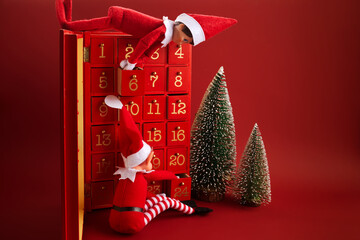 Christmas advent calendar with an elf and gifts on red background