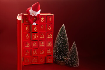 Christmas advent calendar with an elf and gifts on red background