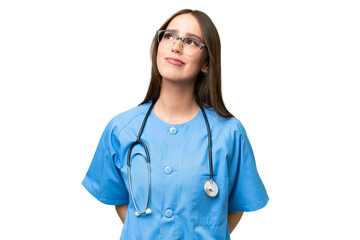 Young nurse caucasian woman over isolated background and looking up