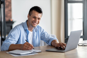 Smiling man student studying online sitting at home, online education or webinar elearning concept