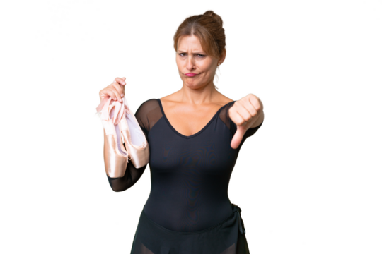 Middle-aged caucasian woman practicing ballet over isolated background showing thumb down with negative expression