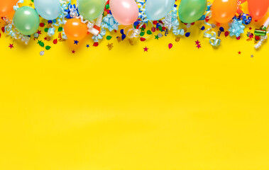 Birthday background top view. Balloons and various party decorations on a yellow background with...