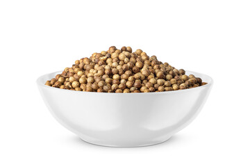 Dry coriander seeds in round bowl isolated on white. Side view.