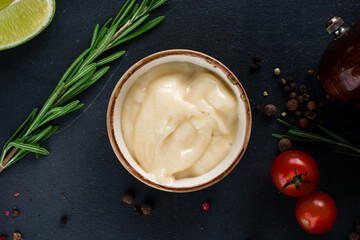 Garlic sauce in a bowl with rosemary, tomatoes, lime and spices.