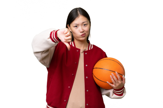 Young basketball player asian woman over isolated background showing thumb down with negative expression