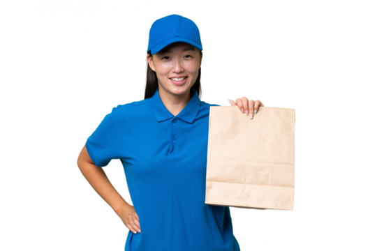 Young Asian woman taking a bag of takeaway food over isolated background posing with arms at hip and smiling