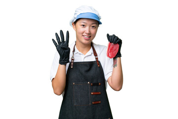 Young caucasian woman wearing an apron and serving fresh cut meat over isolated background happy and counting four with fingers