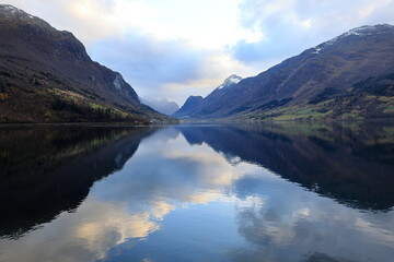 Blick auf den Innvikfjorden bei Loen in Norwegen. Die Landschaft spiegelt sich im Wasser.