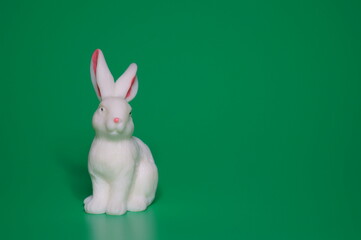 Rabbit figurine on a green background.