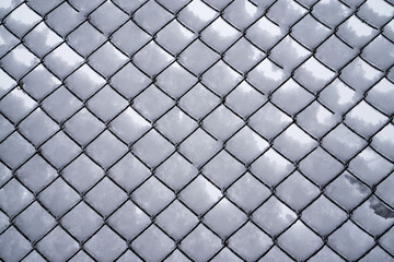 Iron mesh netting in the snow. Abstract winter pattern for the background.