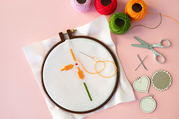 Cross-stitch set: embroidered floral hoop, canvas, colored threads, color palette and scissors. Hobby, handmade home decor concept. DIY. 