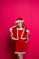 Posing Asian Young Woman at With Christmas Attire on a Red Background