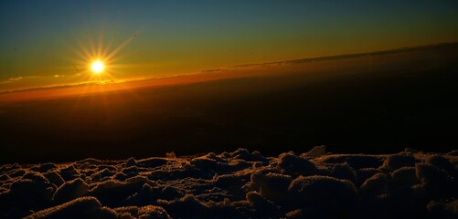 querformat, sonnenaufgang am schöckl im vordergrund schnee
