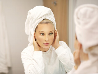 Woman looking in the mirror Applying the cream..Magic anti-aging cream...