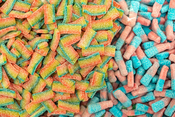 many colored marmalade candies laid out on a flat surface; dessert for the holiday; sweet gifts for children; texture and background with small candies