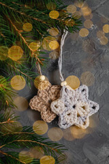 Two crochet snowflace and fir tree branches on a grey background. Handmade jute and cotton Christmas decor. Copy space.
