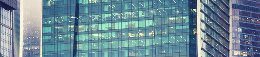 Glass windows of the skyscraper background, copy space. Metal structures with windows of a high-rise building, close-up