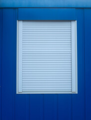 Blue wall with window with external roller blind