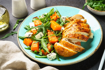 Warm salad with baked chicken breast, pumpkin, blue cheese and arugula. Dash diet, keto diet meal.