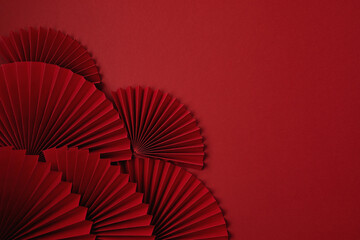 Fototapeta Chinese new year festival or wedding decoration over red background. Traditional lunar new year paper fans. Flat lay, top view, banner obraz