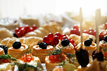 Fruit buffet stand with snacks and cookies served on a white table