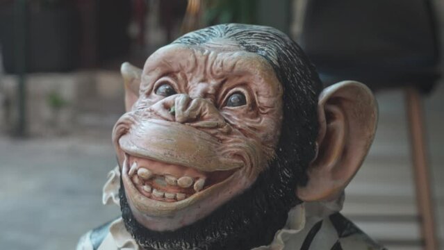 close-up of the face of a toy monkey at the entrance to the cafe. A toy model of a monkey. wax figure of a chimpanzee.