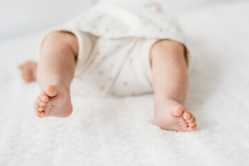 tiny newborn baby feet in bed close up detail  - 549532314