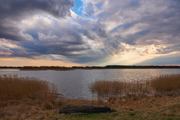 Cloudy afternoon over a lake. Epic clouds on sunset.