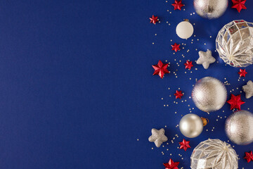 New Year eve concept. Top view photo of silver christmas baubles, red stars and sequins on deep...