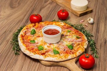 Freshly baked pizza with ham, tomato, and cheese