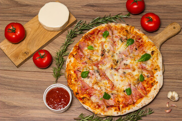 Freshly baked pizza with ham, tomato, and cheese