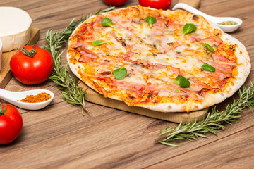 Freshly baked pizza with ham, tomato, and cheese