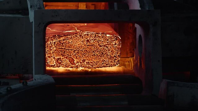 Red hot metal billet moving along a conveyor. A continuous casting and melting shop. Continuous billet casting machine. A continuous casting machine at a heavy industry steel plant