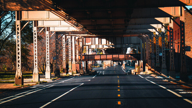 Under the elevated train tracks with light and dark contrast.  Living in urban life has many modes of travel but makes great photo moments.