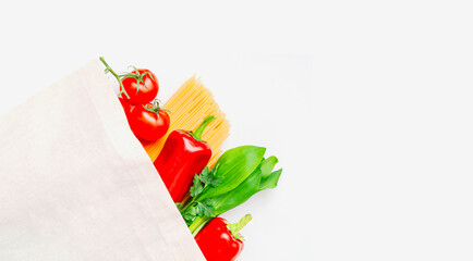 Linen bag with different food and vegetables on light background. The concept of thrifty use of packaging. Close-up