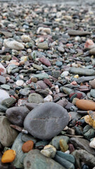 Glistening pebbles on the beach facing the ocean in November after rain