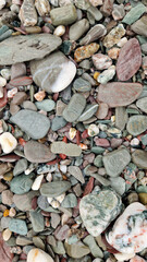 Glistening pebbles on the beach facing the ocean in November after rain