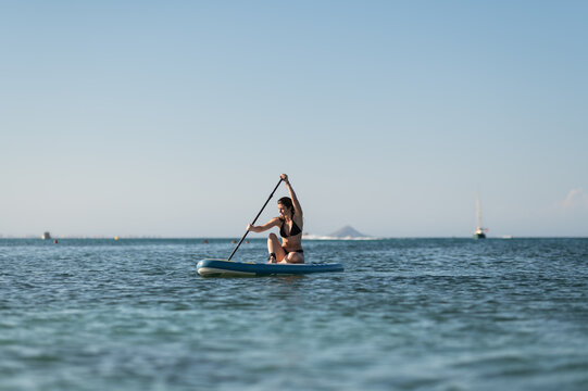 Tourist rowing while floating on sup board in sea