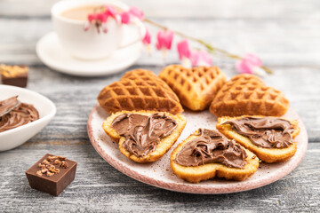 Homemade waffle with chocolate butter on a gray wooden. side view, selective focus.