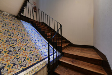 Interior stairs with wooden steps in an old apartment building with decorative tiles - Powered by Adobe