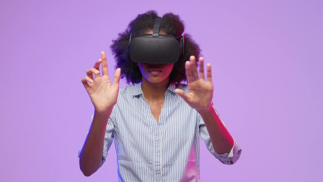 African American woman imagines touching virtual elements wearing VR headset