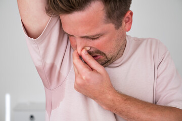 Man with hyperhidrosis sweating very badly under armpit