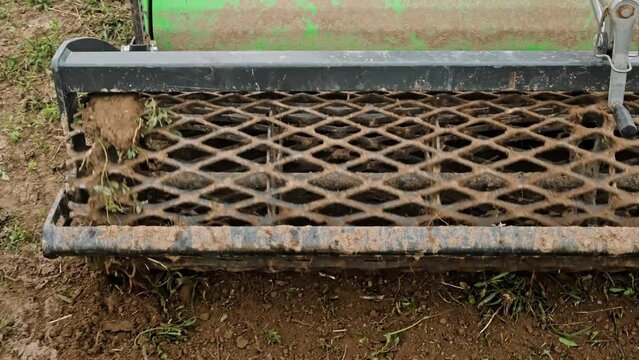 Close-up rotary cultivator attachment of small tractor. Ground leveler. Moving soil. Mini skid steer loader clear the construction site. Land work. Territory improvement.